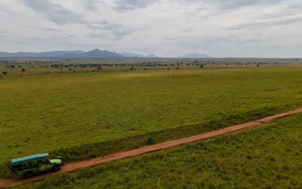 Aerial view of a safari vehicle on a track through Kidepo Valley National Park